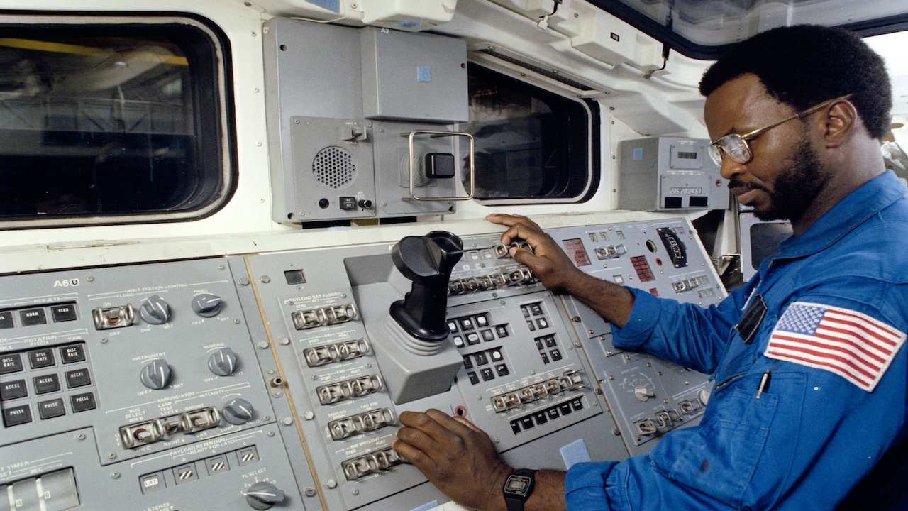 an astronaut working a spaceship control panel